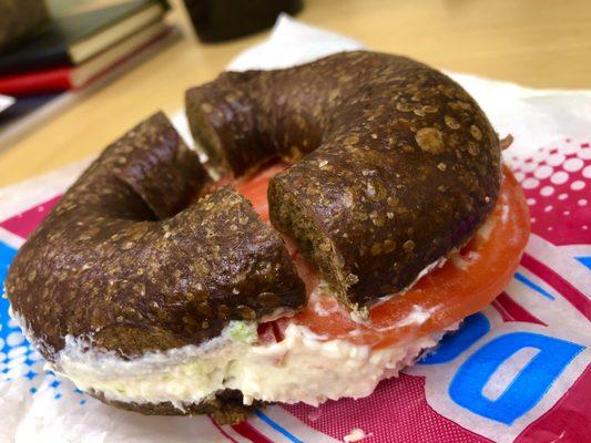 Pumpernickel bagel with vegetable cream cheese and tomato