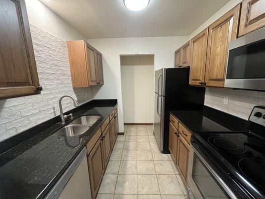 Sleek Granite Countertops, Amish Hickory Cabinetry, and new backsplashes.