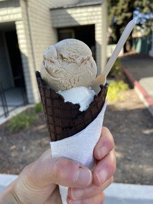 Single of vanilla bean and coffee in a chocolate waffle cone