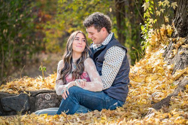 Sitting in the fall leaves looking at each other for couples portraits