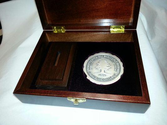 custom die-struck medallion in a custom fitted presentation box which contains a custom made wood base