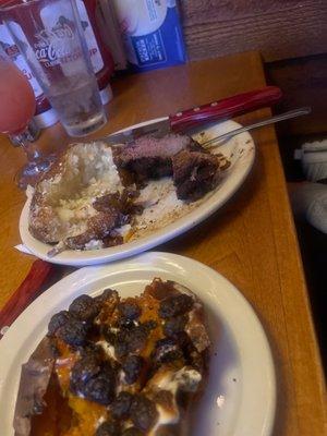 A loaded sweet potato with BURNT marshmallows and a steak that is supposed to be medium rare.