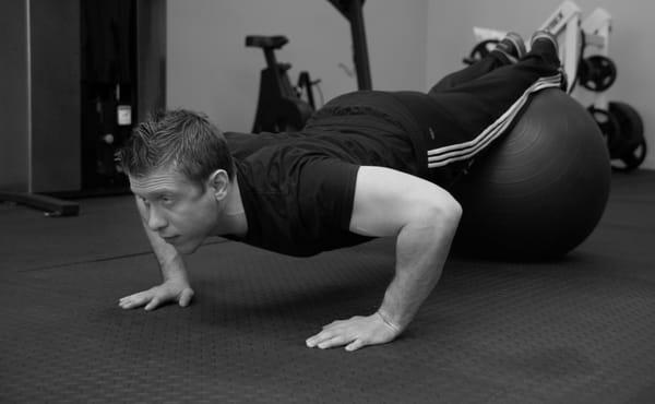 Andrew demonstrates push-ups using a stability ball.