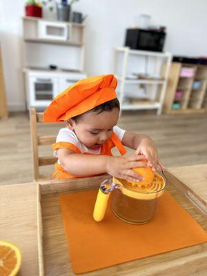 Educational Preschool in Shadowridge, Vista. Practical life activity juicing an orange for snack. #concentration, #focus #fine motor skills.