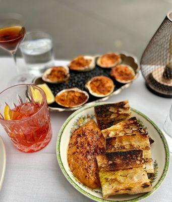 Food: Roasted clams, red aubergine dip with burnt toast, Drinks: Negroni and Anton's Manhattan