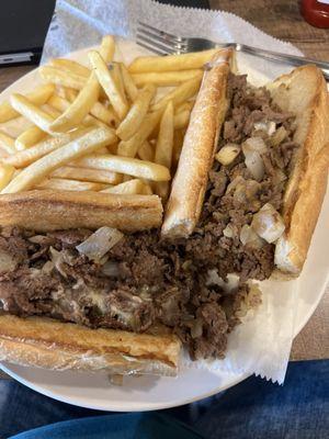 Cheesesteak with fried onions and fries