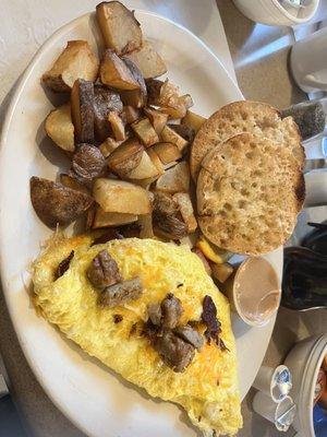 Meat lovers omelet with breakfast potatoes and English muffins.