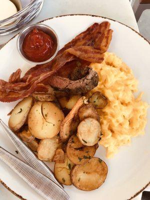 Two scrambled eggs with potato medallions and bacon