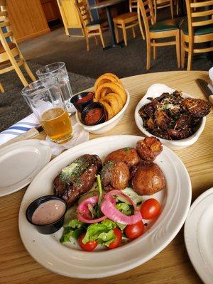 Bavette Steak with red potatoes & salad, Brussel Sprouts, and onion rings.