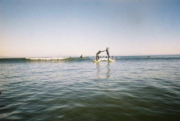 Heath helping my friend stand up on her first wave