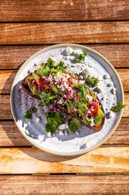 Avocado Toast with cucumber, roasted tomato, fresno chile, cilantro, sesame seed + blue grouse country bread