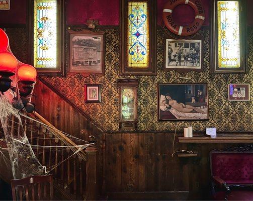 Cool stained glass windows and a stairway leading up to another seating area.