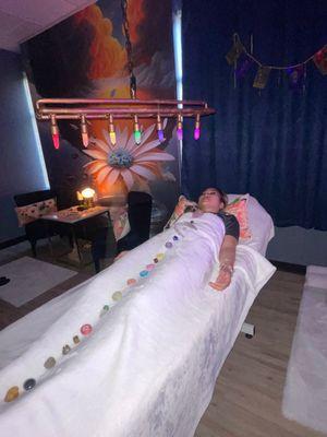 Laying amidst crystals in Reiki meditation harmonizes energy, promoting deep healing, relaxation, and spiritual alignment.