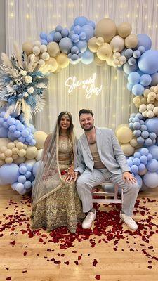 My fiancé and I in front of the balloon arch, dried floral piece, and LED sign put together by Kristina