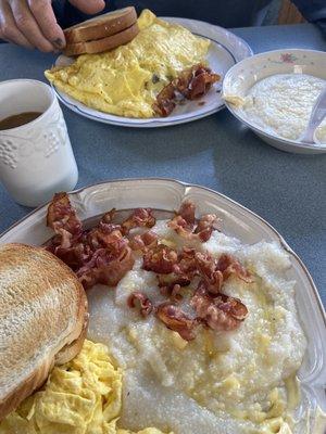 Scrambled eggs, bacon, grits, and toast