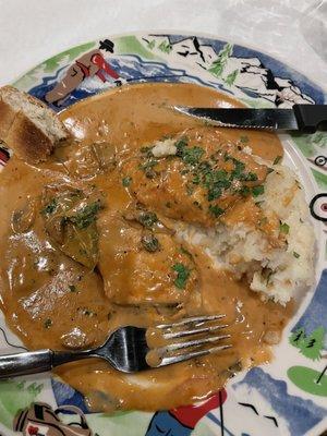 Pork chop with mushroom gravy over mashed potatoes.