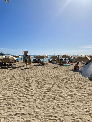 Beach chairs and umbrellas on the beach (employee quickly packing up chairs)