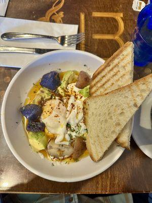 Turkish Cilbir: poached egg on garlicky dill yogurt, avocado, pan fried potatoes in Aleppo chili oil with sourdough. Must try!