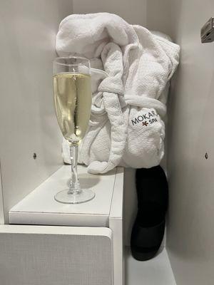 Locker with robes and slippers and my glass of champagne lol