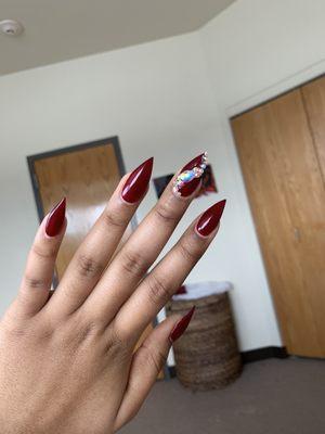 Burgundy, stiletto shape, no chip gel, with a little dazzle dazzle on the middle finger. $45 for everything (the gems were extra though)