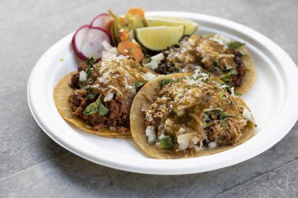 Chorizo, Pollo, and Adobada tacos with spicy red salsa