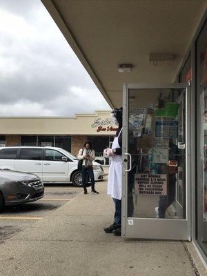 Doorman wearing gloves and face shield.