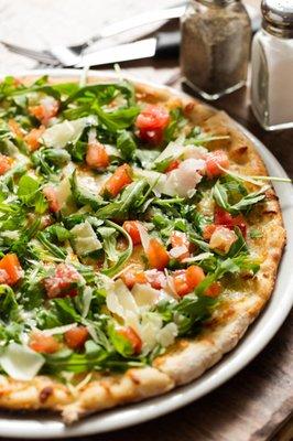 Truffata Pizza: Homemade pizza dough. Grana Padano parmesan shaves, arugula, fresh tomatoes, truffle oil