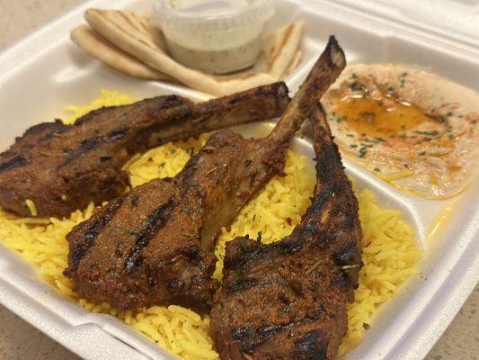 3 Piece Lamb Chops, (garlic, rosemary, thyme, olive oil, grilled) served with Hummus, Pita Bread, and Rice.