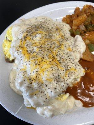 A version of biscuits and gravy with eggs and sausage on it served with home fries.