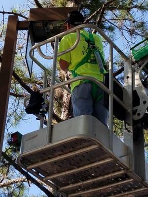 Jason changing a ballast on a parking lot light from a lift.