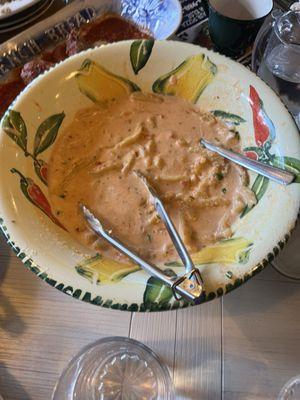 Half empty family style bowl  of Paulie's 8 Finger Cavatelle with vodka sauce