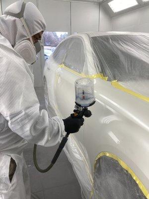 Our Paint Technician working diligently to bring a luxurious paint job using PPG Paint Material