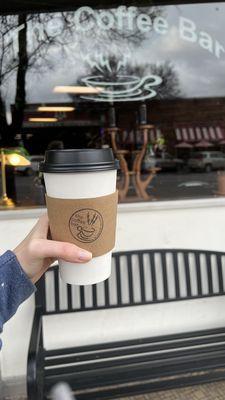 Hot cafe latte with almond milk, storefront