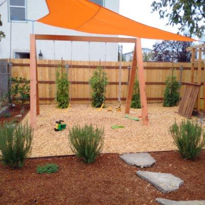 Play area and structure for children. All natural kids garden with shade sail.