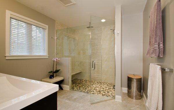 This contemporary bathroom features a curbless shower and warm beige tiles.