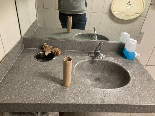 Hand towel roll on counter, trash, soap dispenser not put in proper place