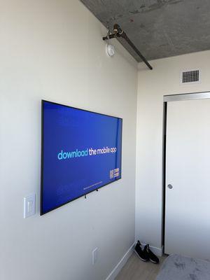 The TV is mounted on the wall. The wires are not visible as they are hidden inside the wall.