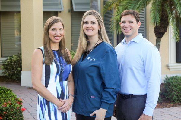 Drs. Lacy and Rich Gilbert with Pelican Landing Dental's Office Manager, Ashley