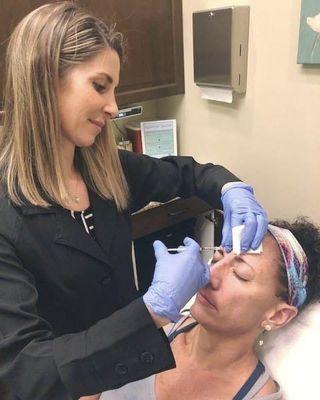 Dr. Laura injecting Xeomin (similar to Botox, which we also provide) into one of our beautiful patients