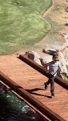 Five-year-old on a small bridge below the patio