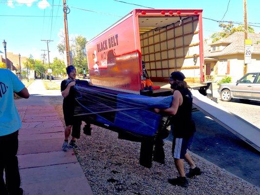 Black Belt Movers moving a HUGE antique table into my new home after wrapping it up and game planning on how to get it in!