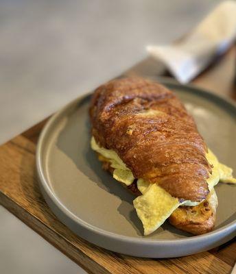 Breakfast sandwich on a croissant with egg, Swiss, and bacon. Very tasty.