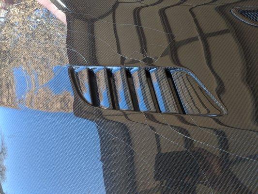 Cracks from VIS Racing's faux hood vent. Poor quality carbon and no warranty.