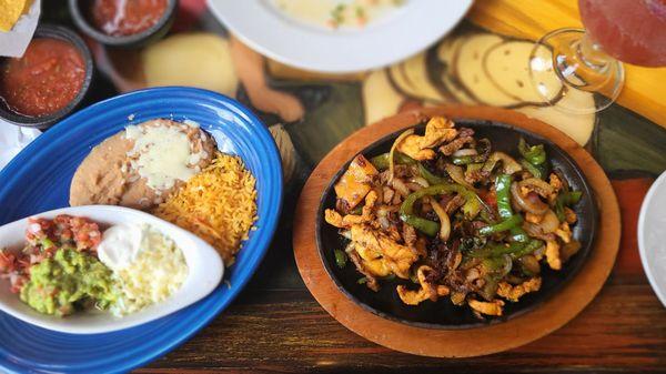 Fajitas texanas (shrimp, steak, & chicken). Comes with flour or corn tortillas and all the sides shown.