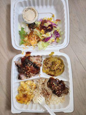 Replated: salad, jerk pork, curry chicken, macaroni and cheese, white rice, and jerk meatloaf.