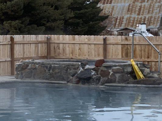 Hot tub with trickling waterfall into pool.