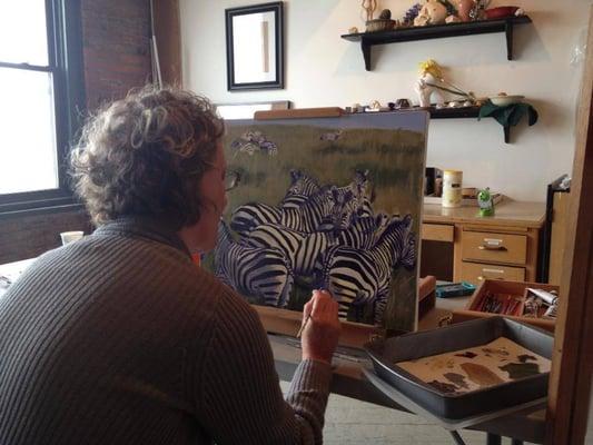 A student working on a wildlife oil painting during a private lesson at Red Door Studios.