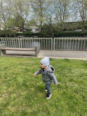 My son running to the playground. Cedar River in the back