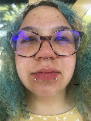 Septum and double lip piercing with opal studs.