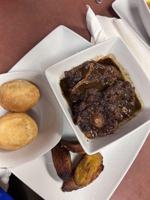 Oxtail with bread and fried plantains.